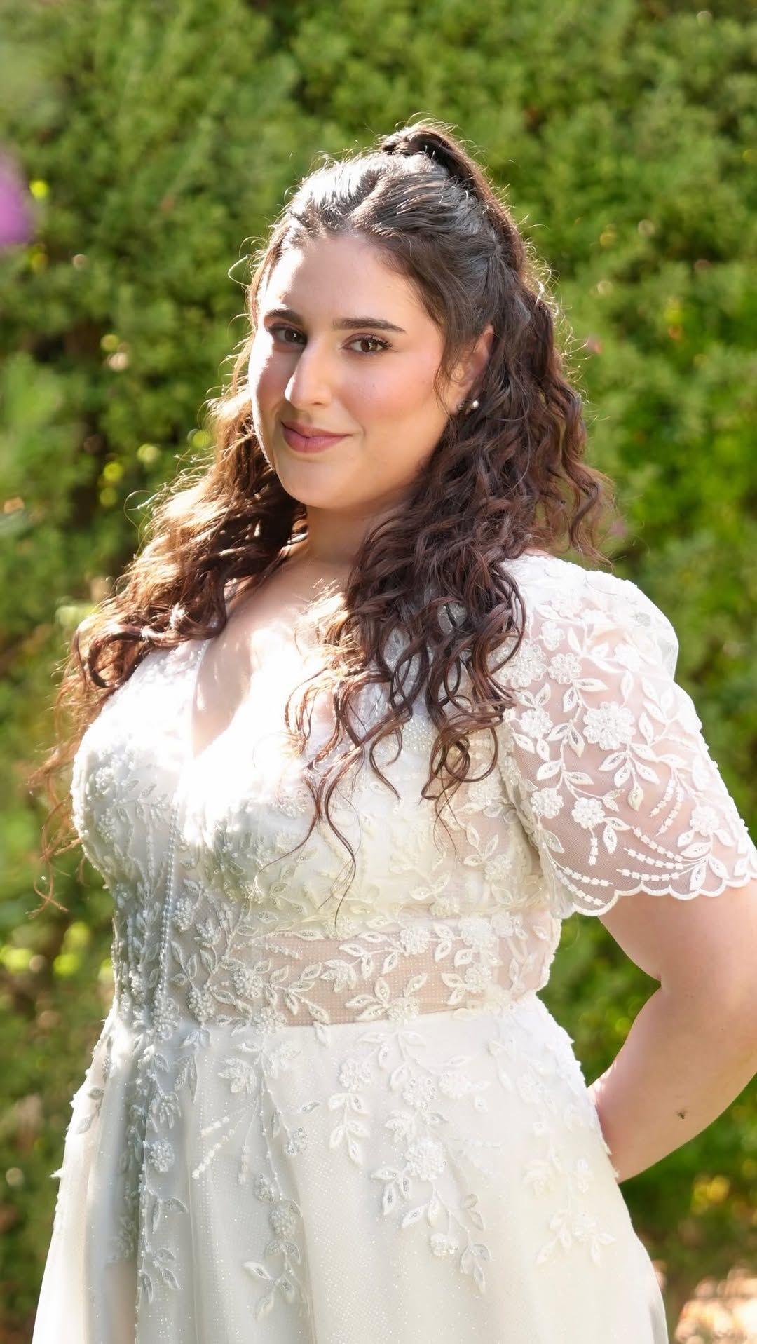 כלה בשמלת תחרה עם תסרוקת חצי אסוף